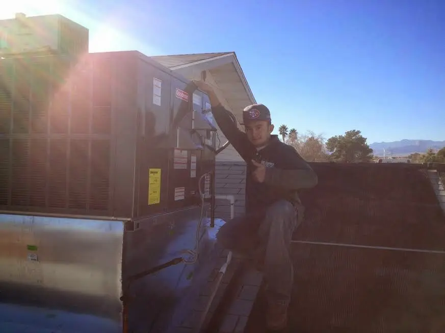 HVAC technician performing AC Tune-Up on a rooftop unit in Skaneateles